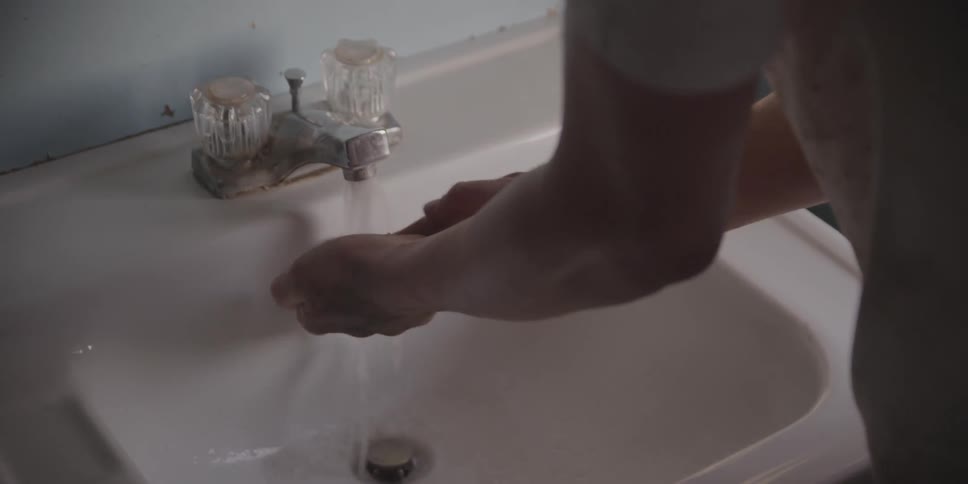 A man washing his hands in a sink