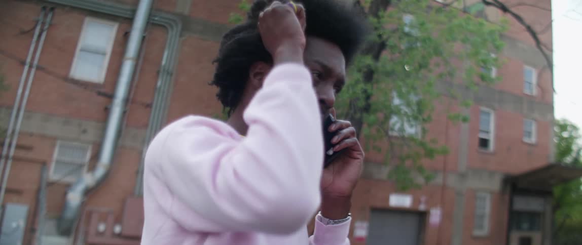 Man talks on a phone while combing his hair
