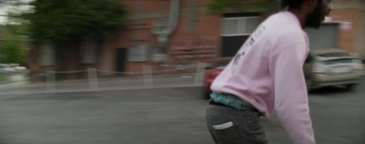 A man is riding a skateboard in a parking lot in a city