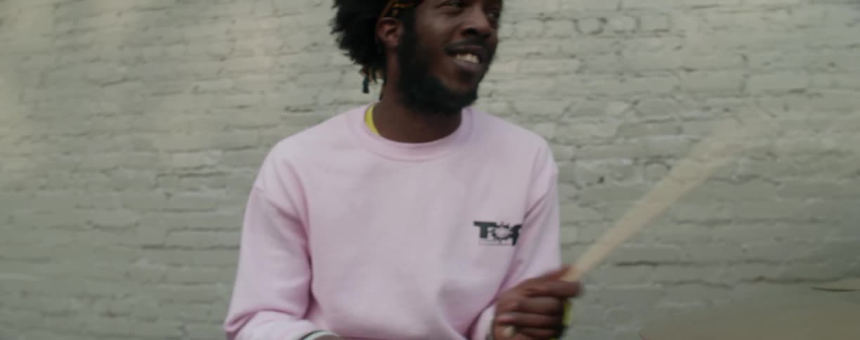 A man is playing the drums outdoors