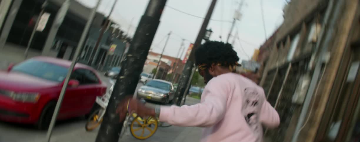 A man is skateboarding down the sidewalk