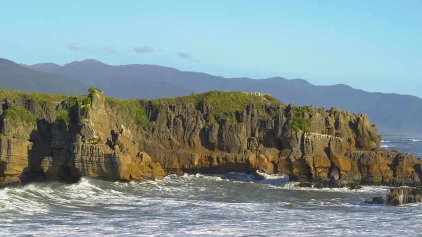 Ocean waves crash into rocky shore