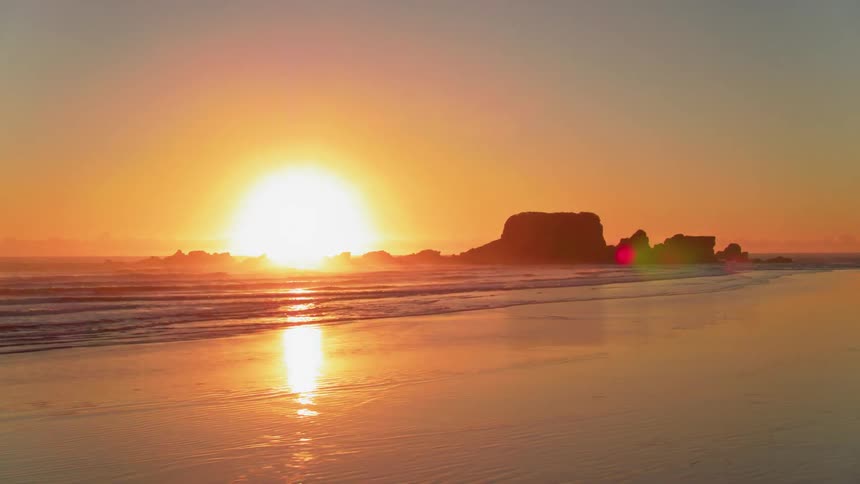 The sun is setting over a beach
