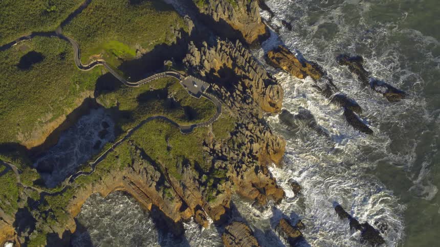 The waves are crashing against the cliffs of this island