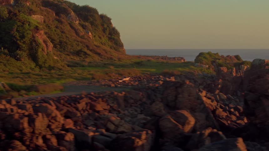 The run is setting behind the island with waves crashing on the side