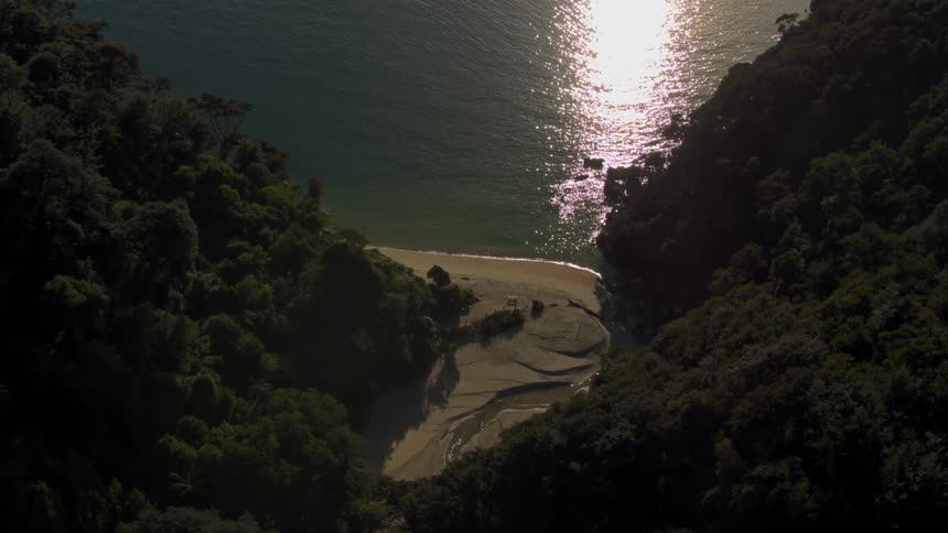 The sun is shining on a remote beach and lagoon at sunset