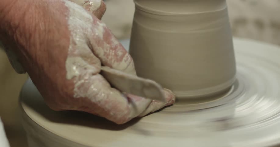A person works with clay on a ceramics wheel