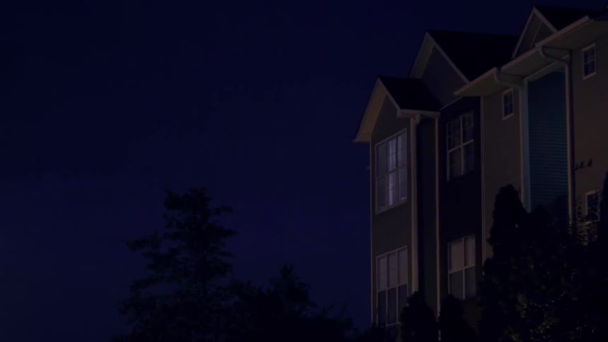 Lightning flashes near a building at night