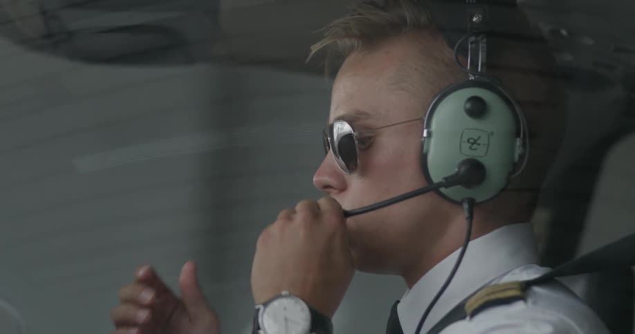 Pilot puts on headphones in cockpit