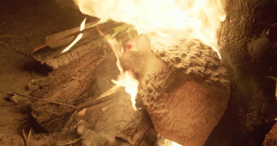 A sheep mask burns in a fire