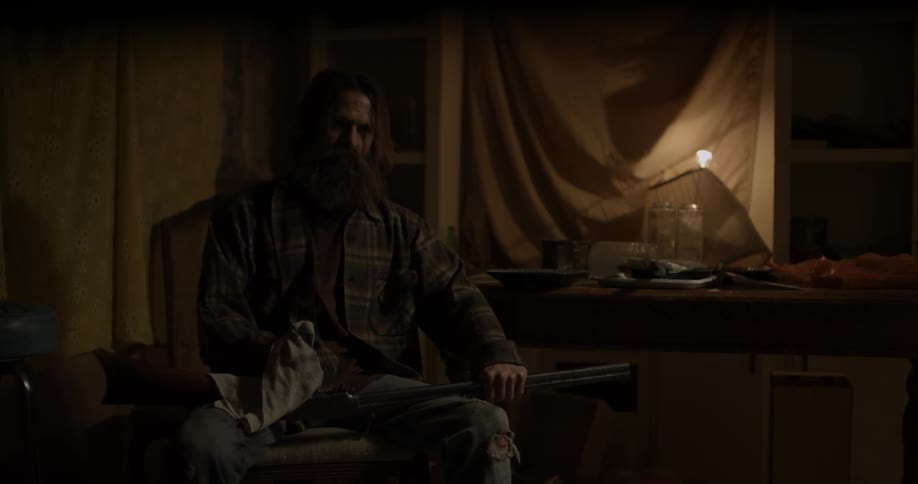 Man cleans a gun in a dark room