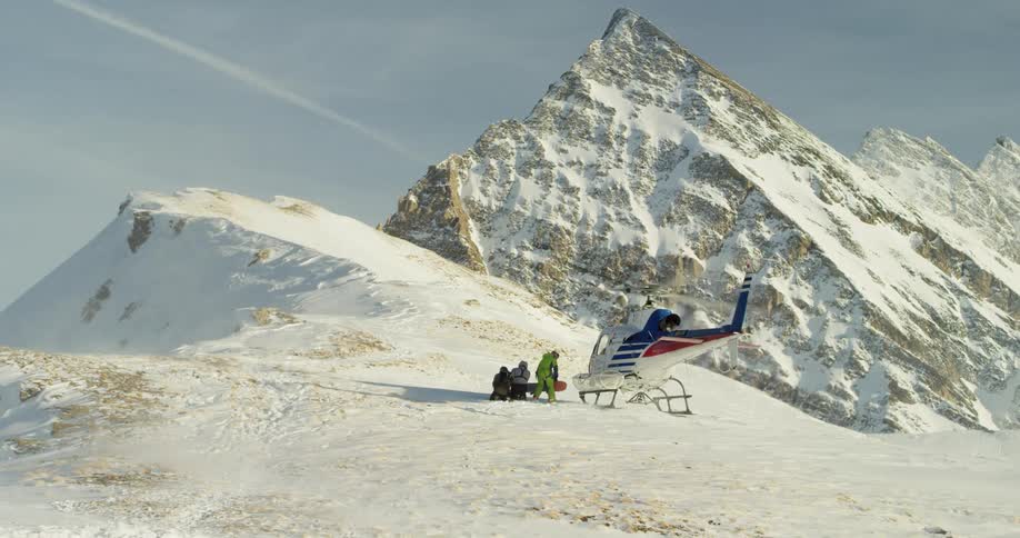A helicopter lands near a group of people