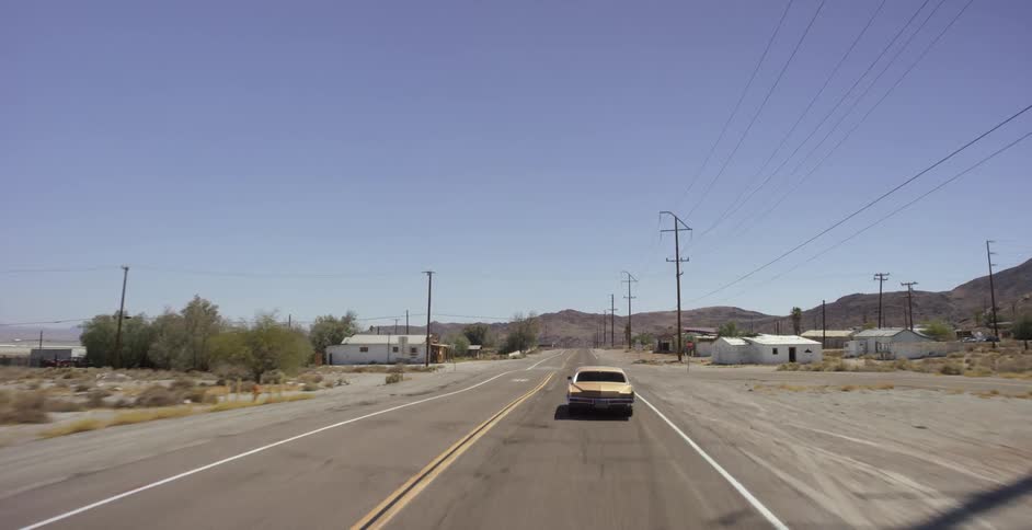 Car drives through a small rural town