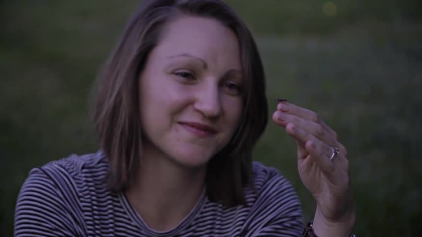 Firefly glows on woman's hand