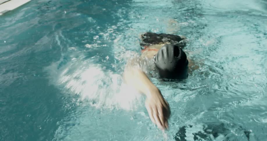 A woman is swimming towards the camera