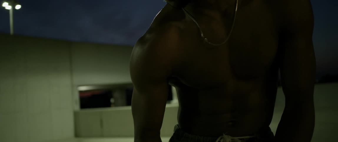A man cringes as he dances on a parking garage level at night