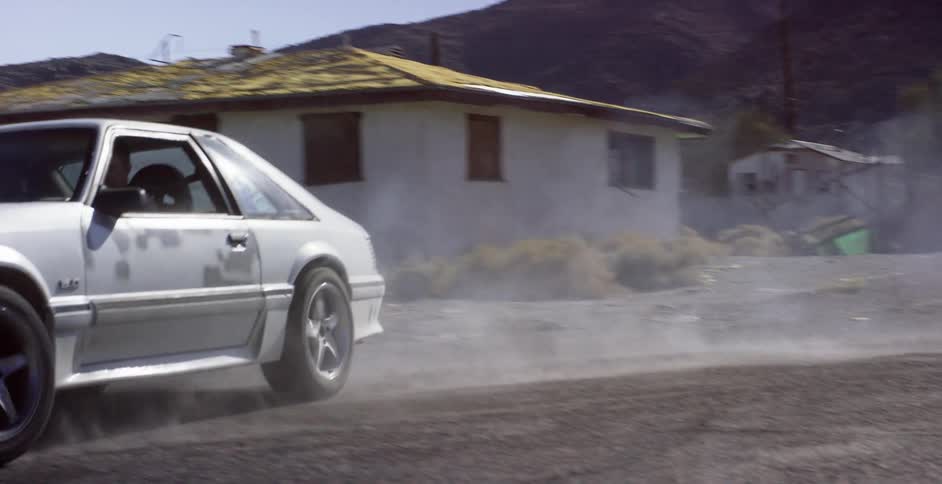 A small car races off down the road