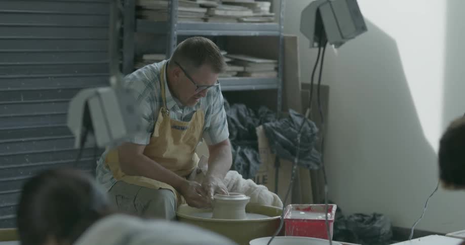 A man is teaching a pottery class