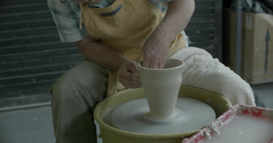 A man is shaping up clay