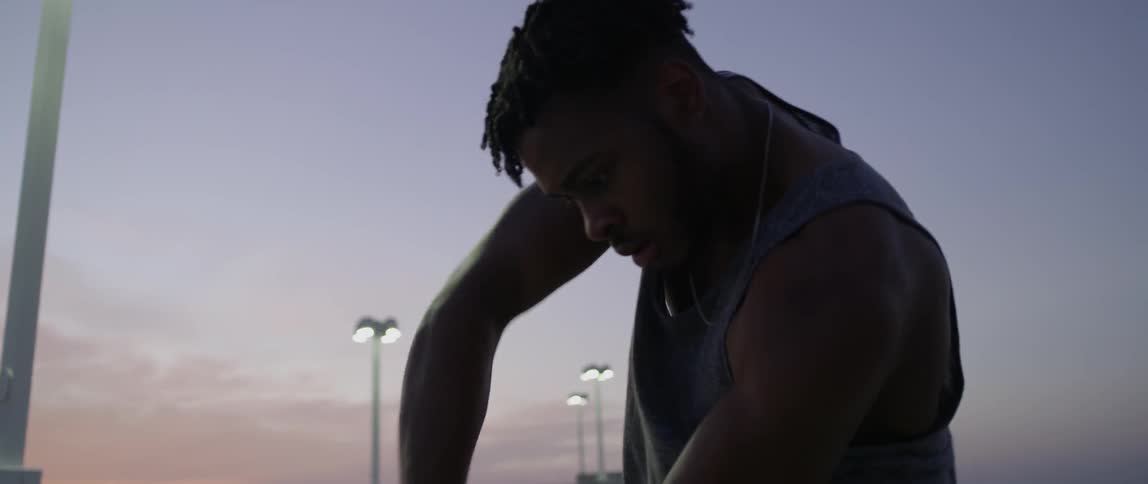 A man dances under a stadium light