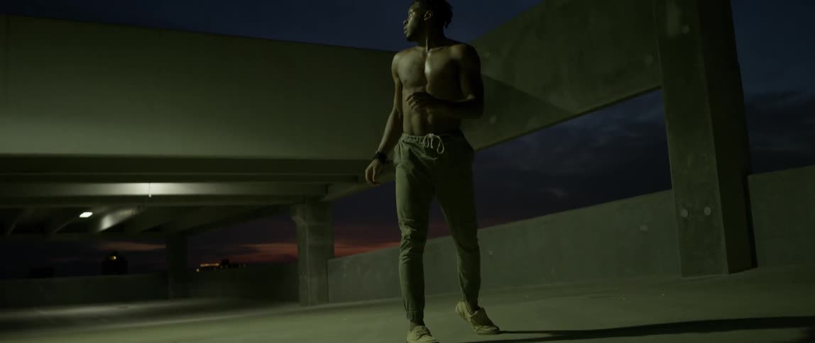 Man dances in a parking ramp at night