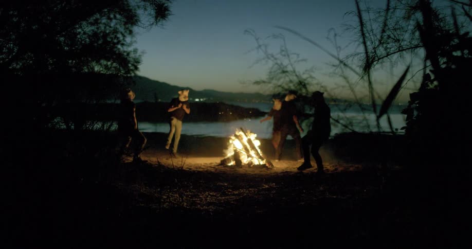 People dance and run around the campfire