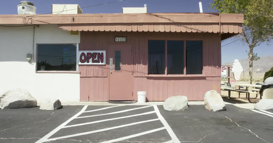 A roadside diner with a large open sign is pictured