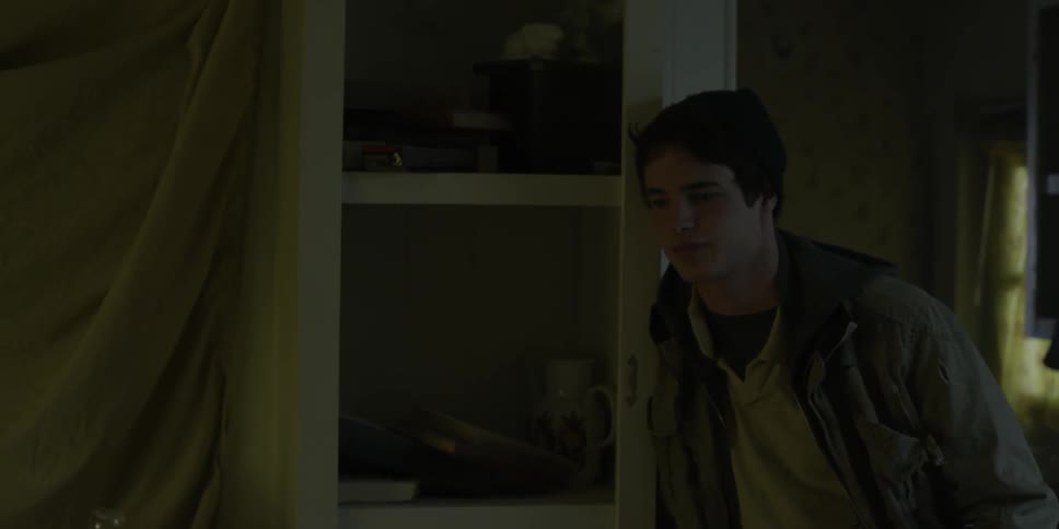A man leans against a cabinet