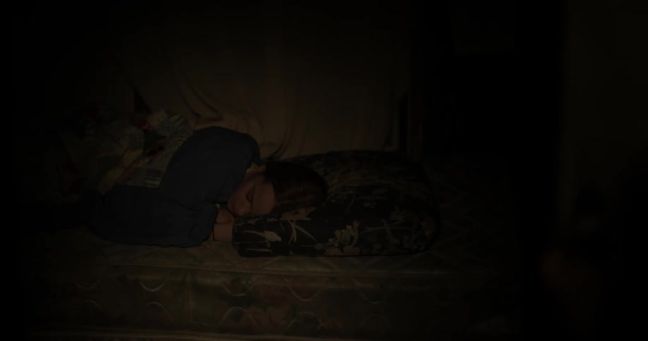 Woman sleeps in dark bedroom