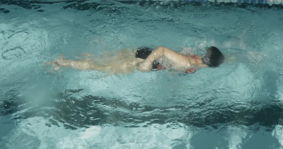 An overhead view of a woman swimming past the camera