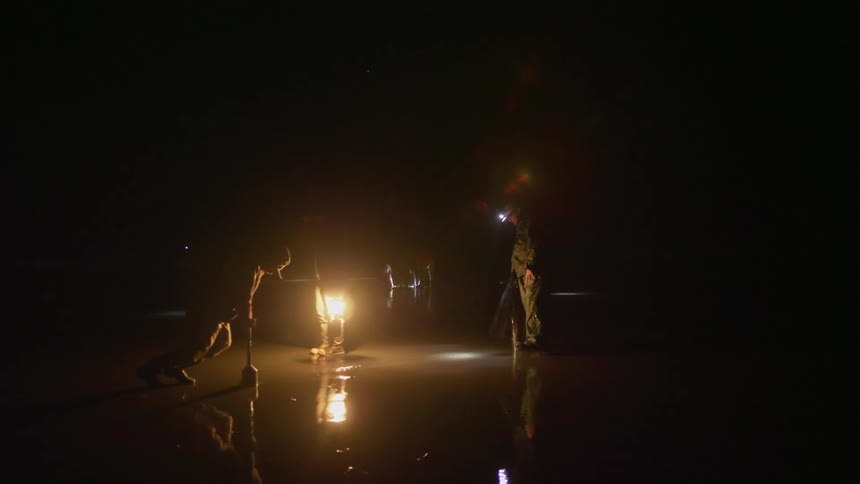 People digging in mud at night