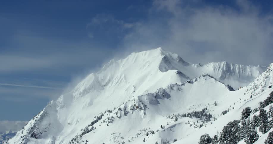 Snow clouds drifting atop high mountains