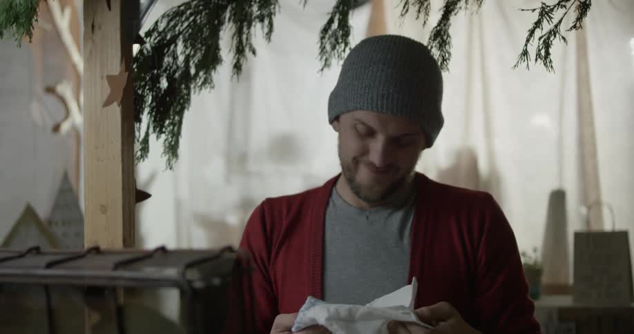 A man examines some baby clothing and folds it back up