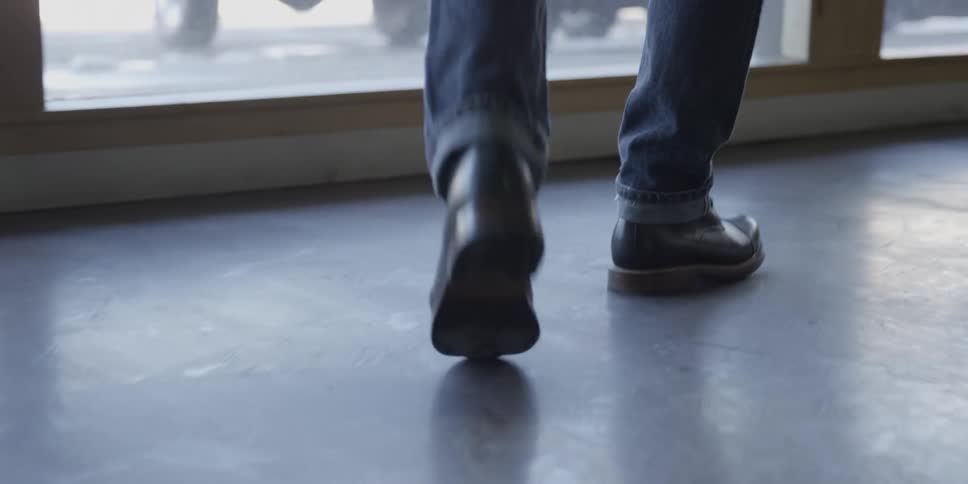 A person walks toward a large window