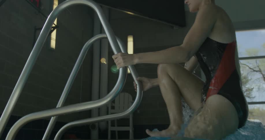 A woman is climbing out of the pool