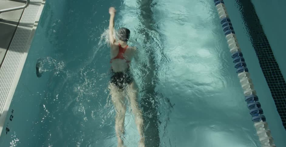A woman is swimming in a large pool