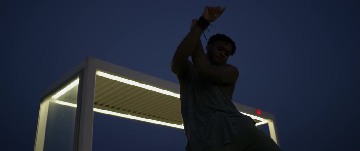 A man is dancing outdoors at night