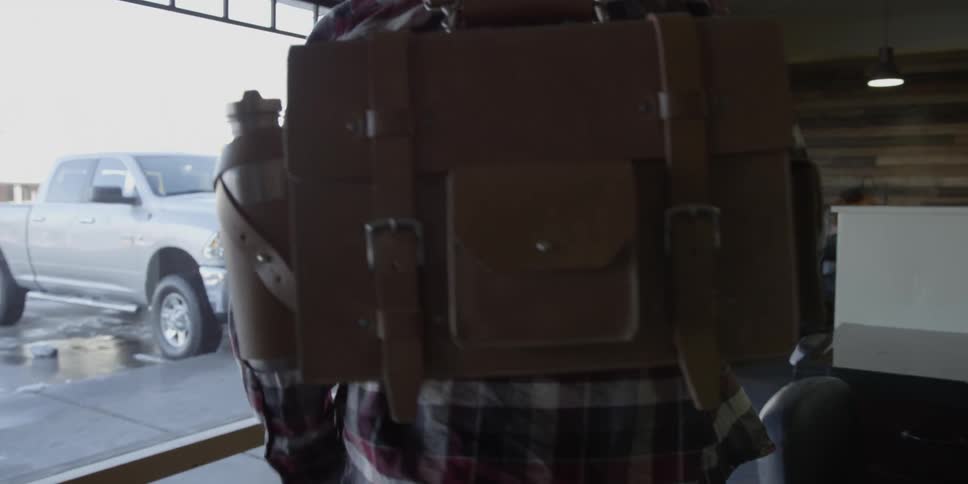 A man wearing a backpack walks in a store