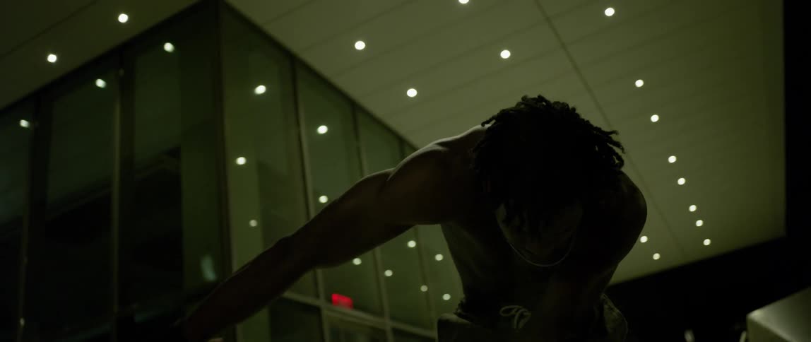 A man is waving his arms and dancing outside at night