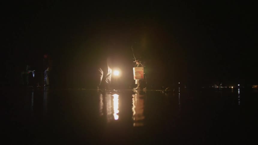 Men carry buckets in the dark