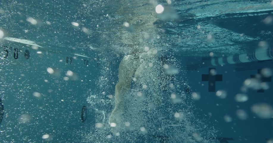Woman swims in a pool creating bubbles