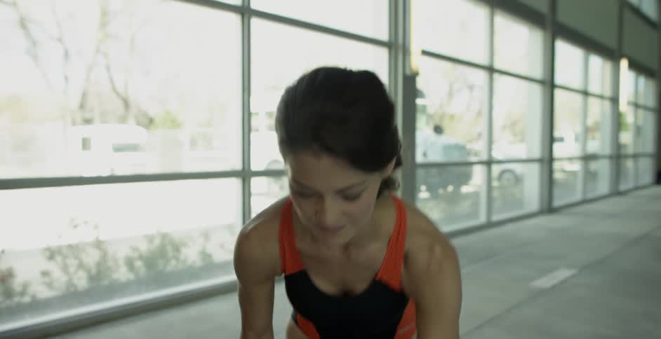 A woman is preparing to go for a swim at an indoor pool during the day