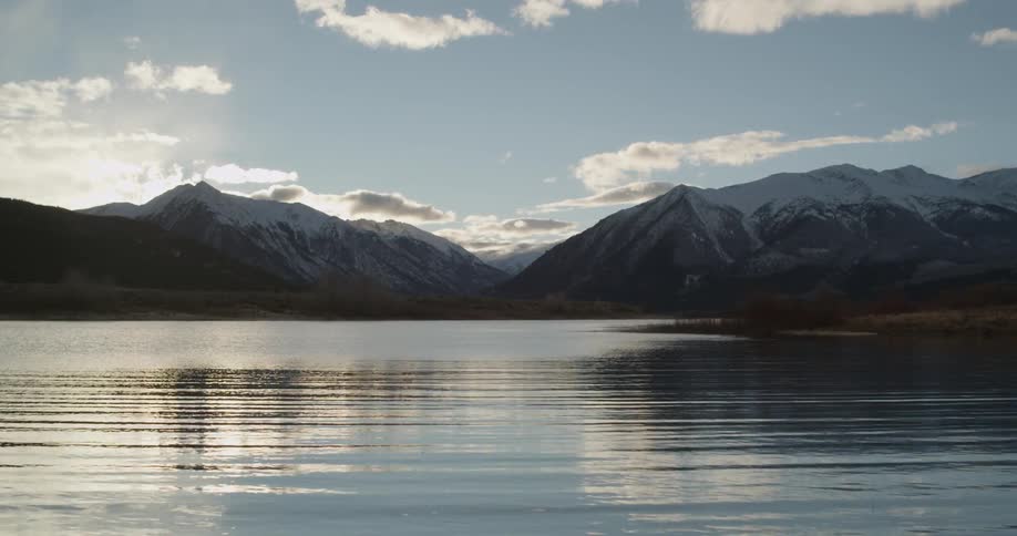 Water ripples on a lake in front of mountains