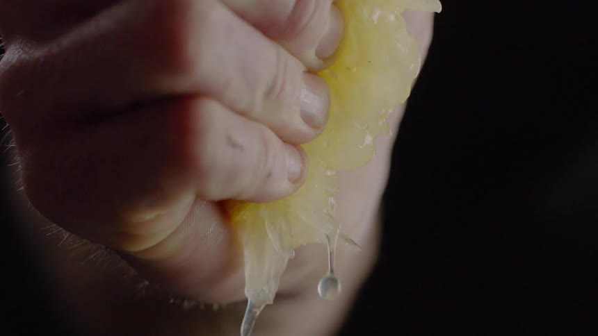 A hand squeezes a lemon