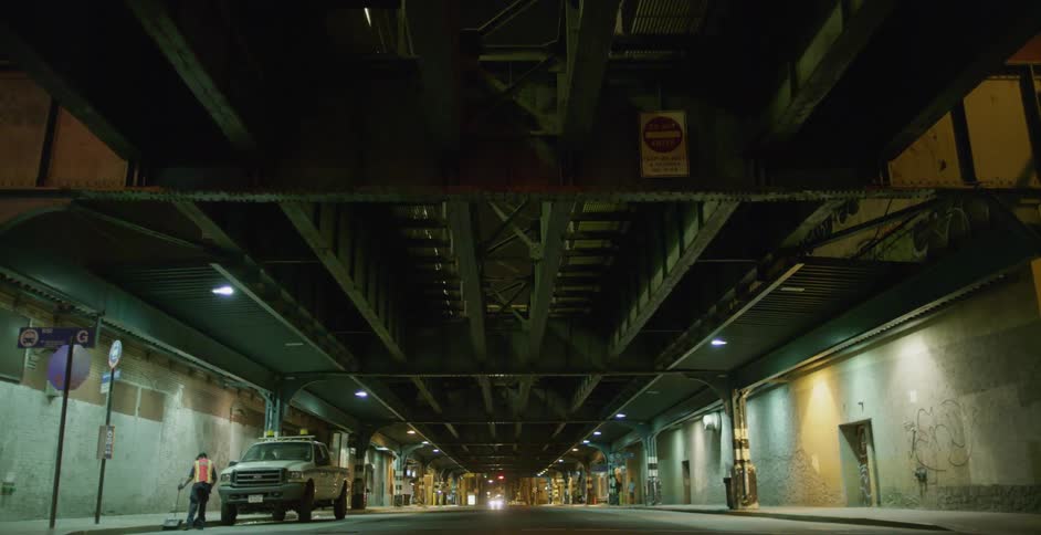 Traffic light flashes beneath city bridge