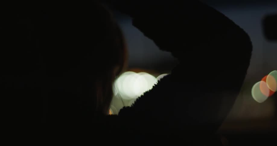 A young white woman plays with her hair while driving a car