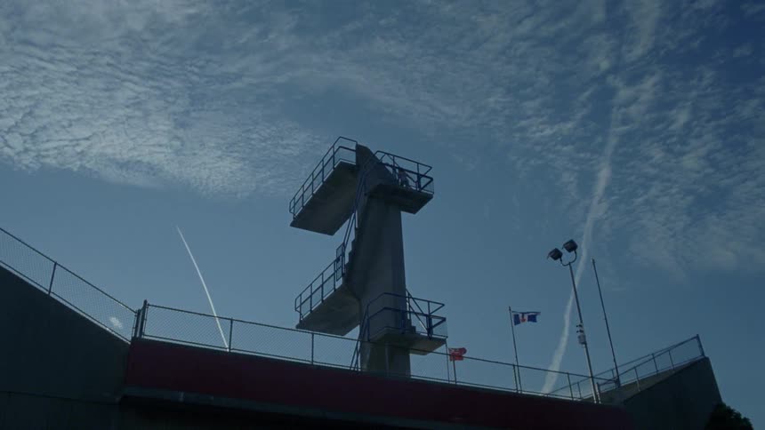 A person climbs up a tall diving platform