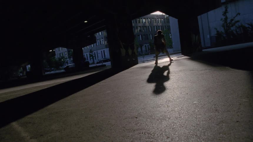 A man is dribbling a basketball in the lot