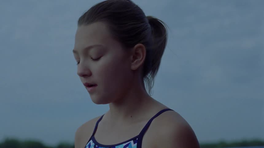A girl in a ponytail takes a deep breath