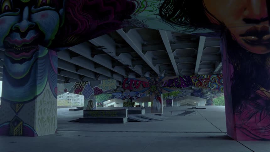 Graffiti and murals cover concrete at skate park